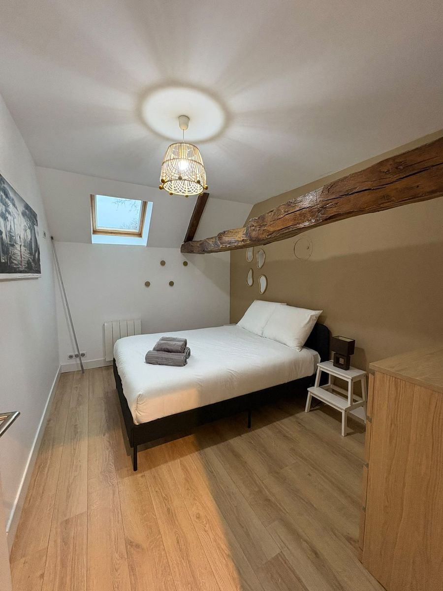 Chambre rénovée et décorée sous les combles, poutre apparente